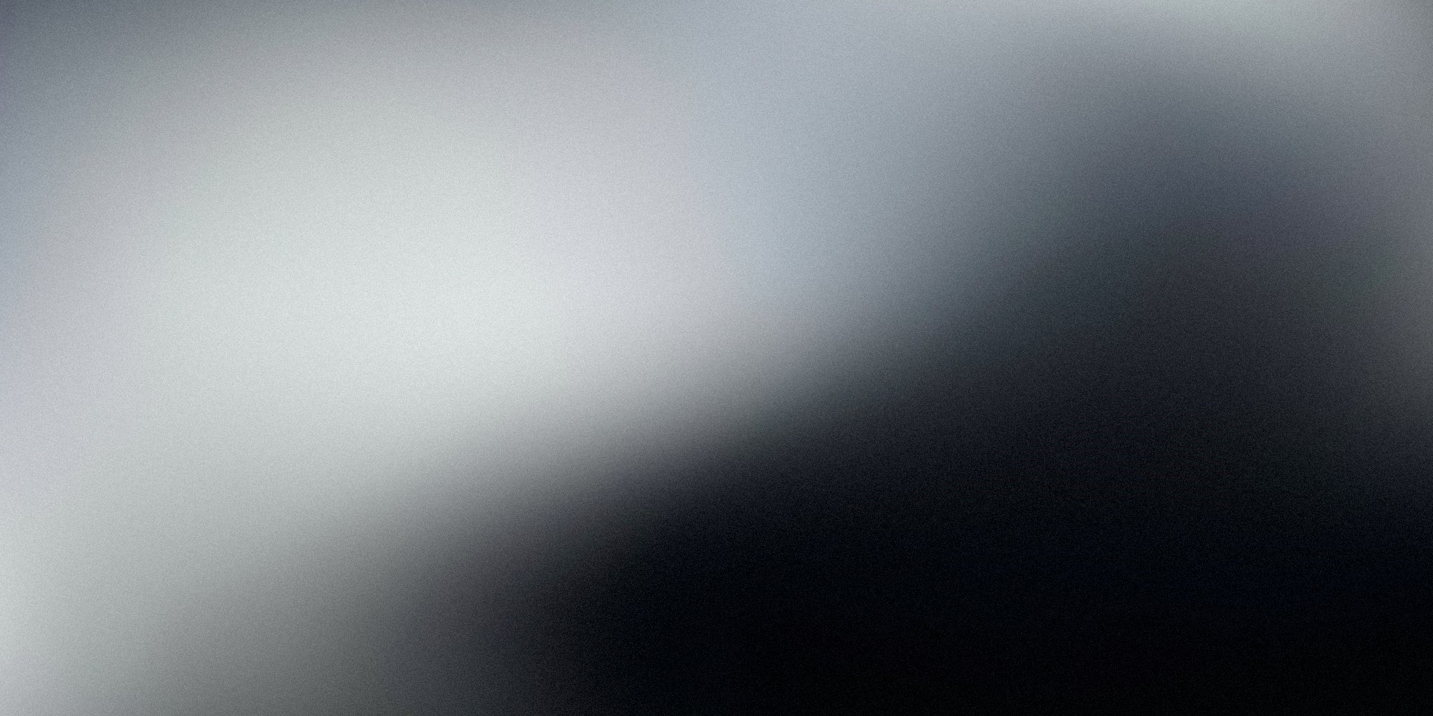 Minimalist black and grey gradient background with a soft, abstract blurred effect.