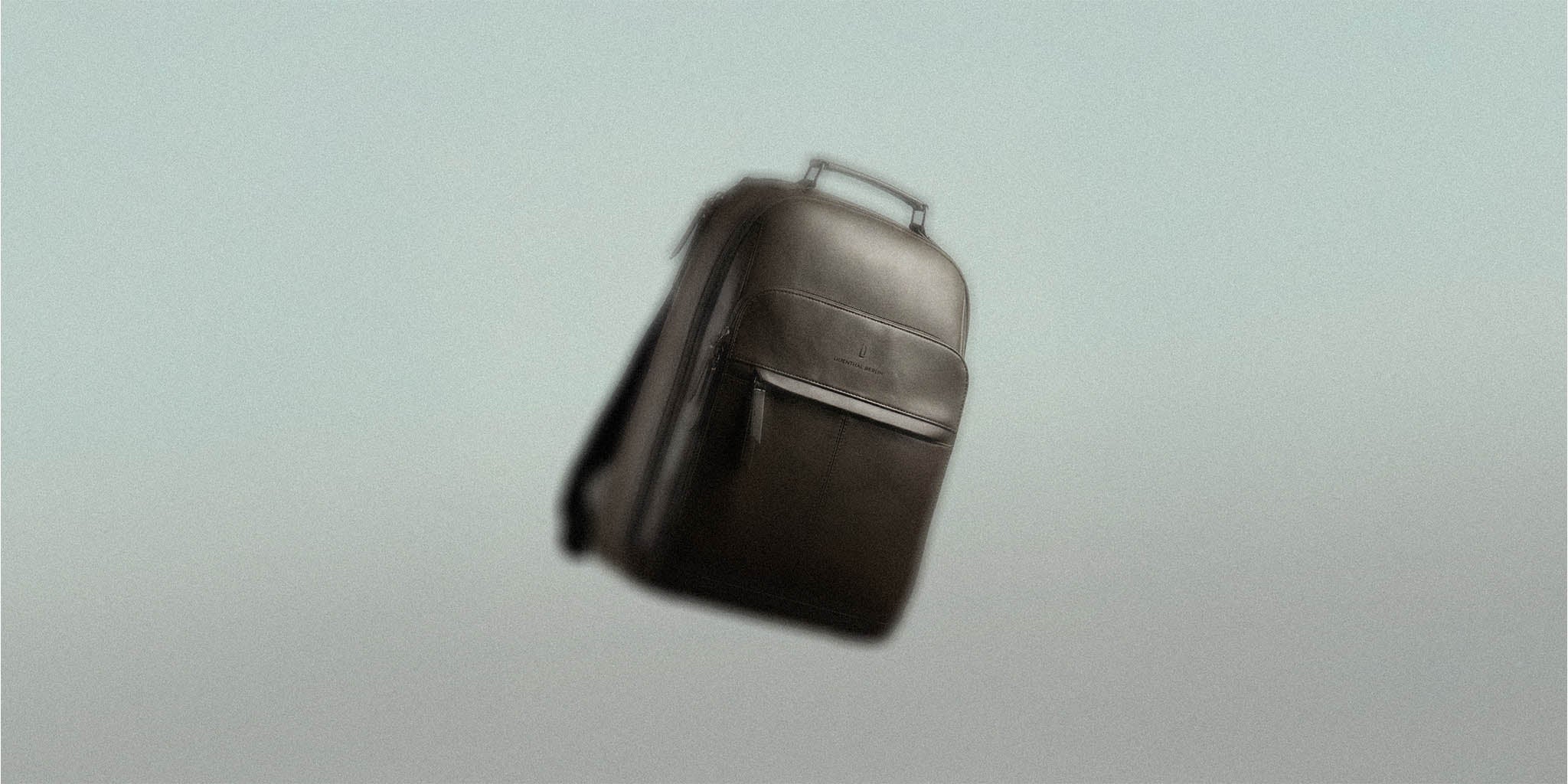 Modern black backpack with top handle floating on light background, minimalist design