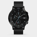 Black solar-powered chronograph watch with mesh strap, checkerboard dial, date display