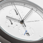 Minimalist chronograph watch face with subdials, white dial, sleek hands, visible date window