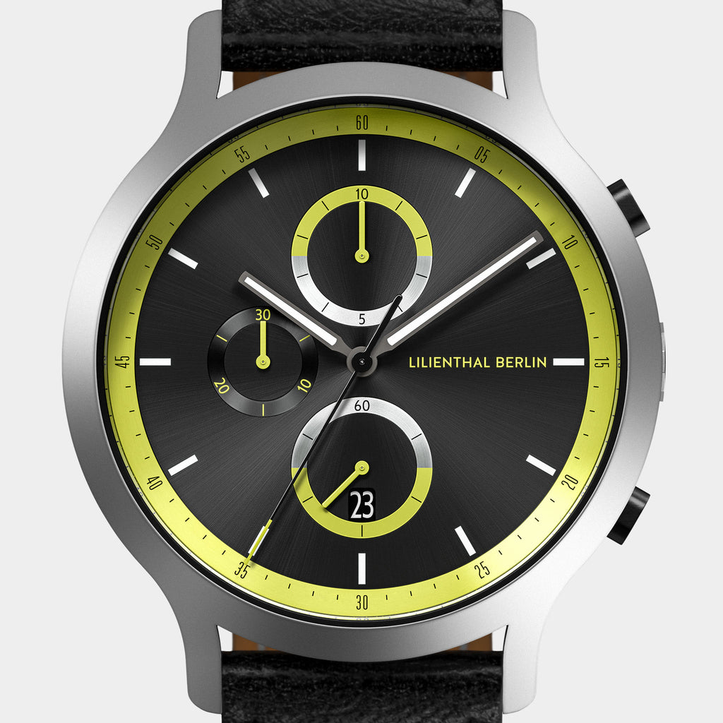 Modern chronograph watch with black dial, yellow accents, and black leather strap