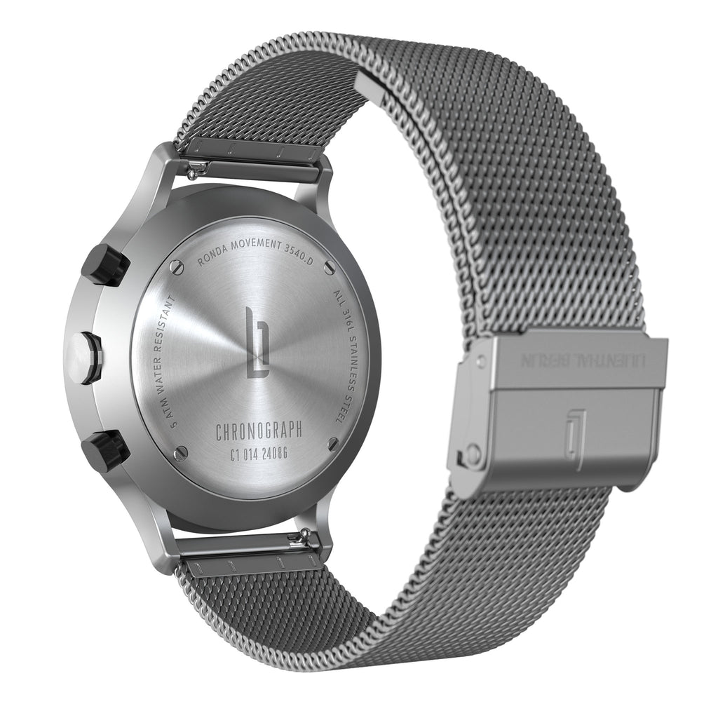 Stainless steel chronograph watch with mesh band viewed from the back, showing engraved case details.