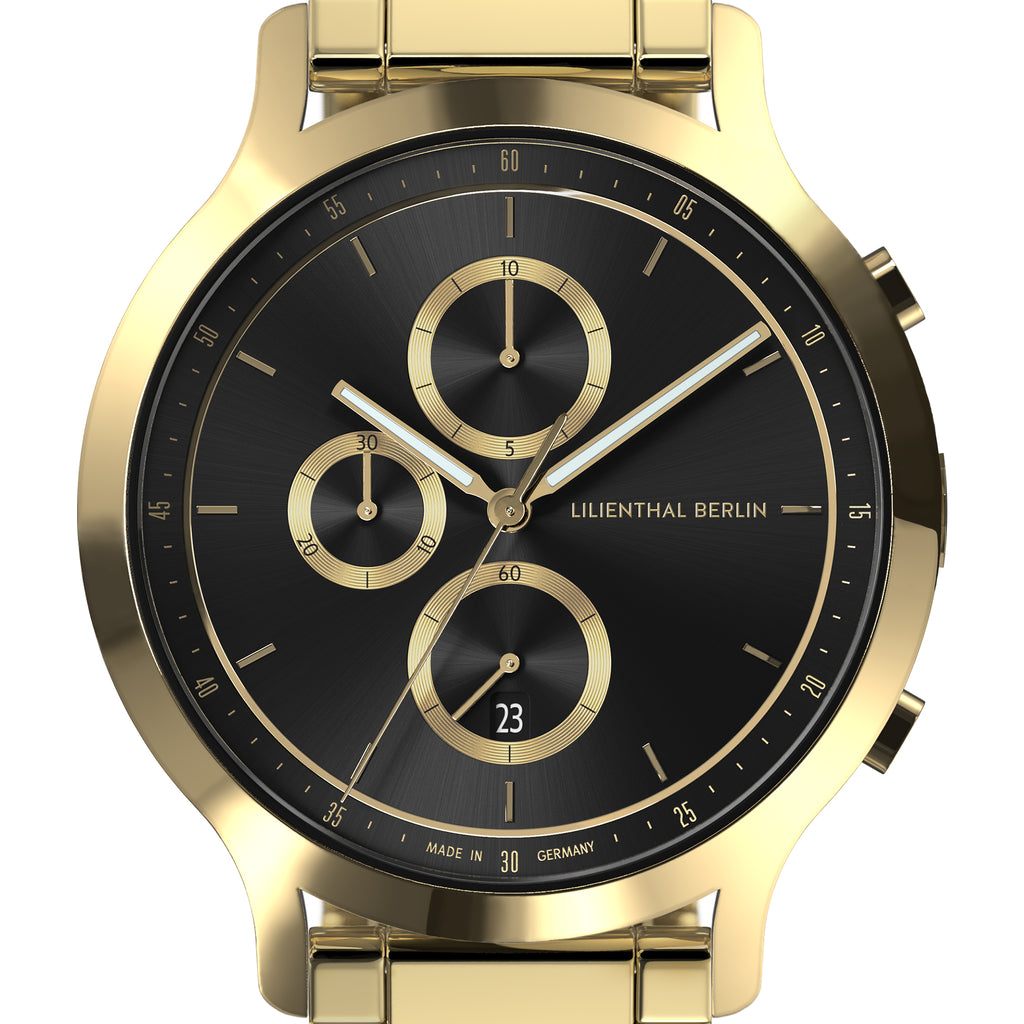 Gold chronograph watch with black dial, gold accents, and three subdials, close-up view