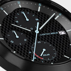 Close-up of a black solar-powered chronograph watch face with subdials and checker pattern.