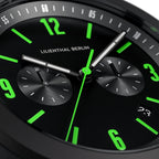 Close-up of modern black watch face with green numerals and chronograph subdials