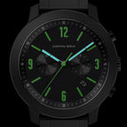 Black chronograph watch with green markers, blue hands, and date display on black background