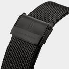 Black stainless steel mesh watch strap with engraved clasp, close-up view