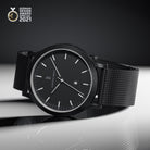 Minimalist black designer watch with mesh strap and date display, German Design Award 2021 winner