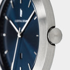 Close-up of minimalist wristwatch with brushed stainless steel case and blue dial