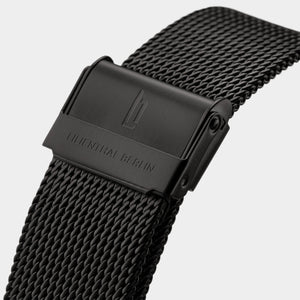 Close-up of black mesh watch strap with engraved clasp and modern textured finish