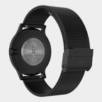 Close-up of a black stainless steel mesh watch strap and engraved watch back
