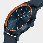 Modern navy blue watch with orange accents, black leather strap, and minimalist dial.