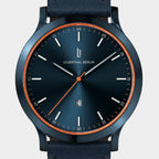 Sleek blue wristwatch with minimalist dial, orange accents, and date display