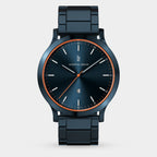 Modern blue metal wristwatch with orange accents and minimalist dial on white background