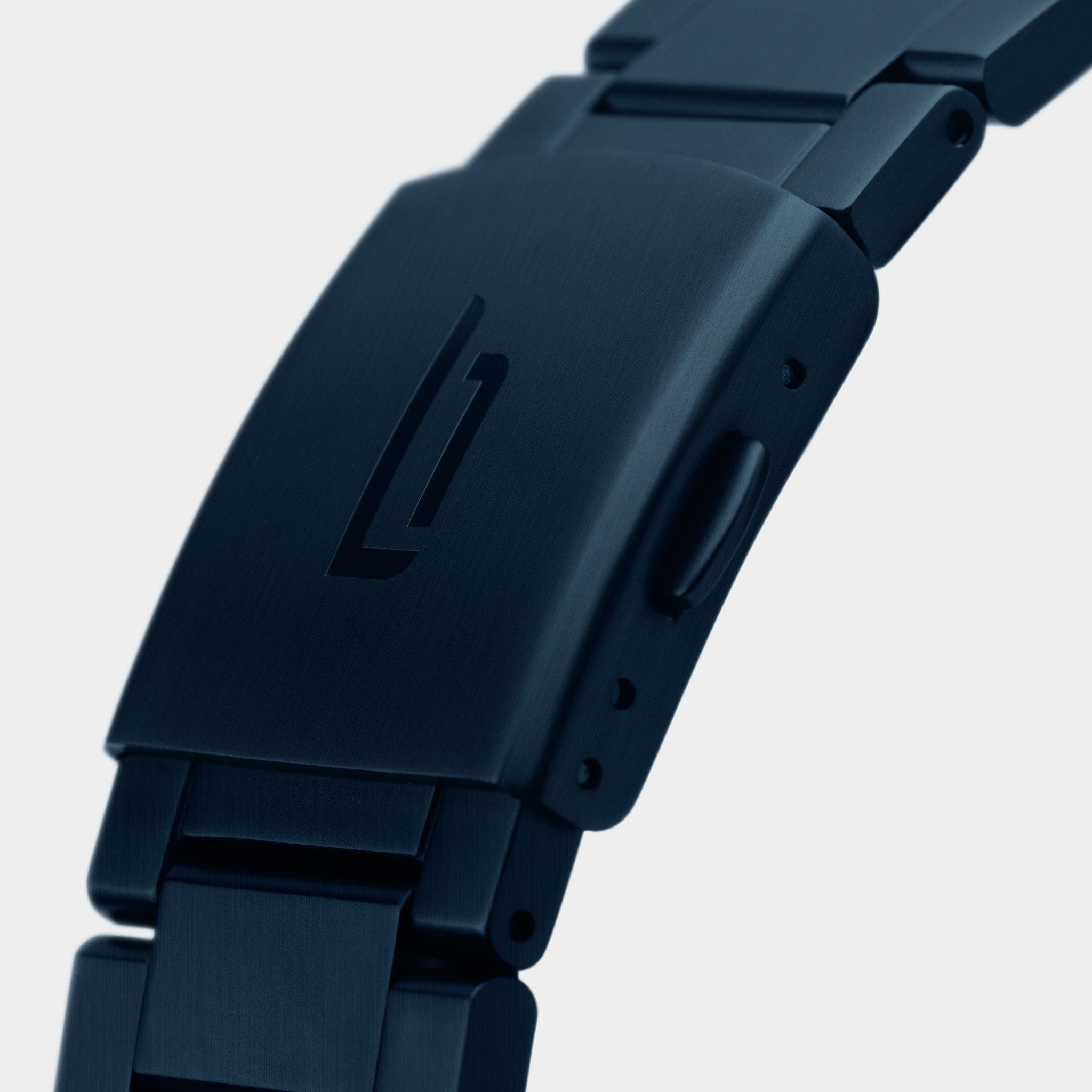 Close-up of matte black stainless steel watch clasp with engraved logo on bracelet