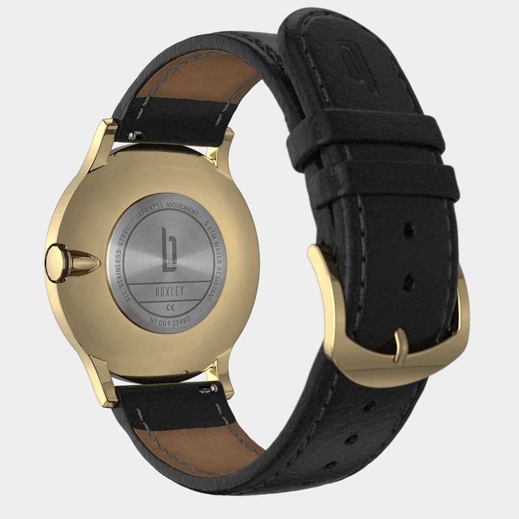 Gold stainless steel watch case with black leather strap, engraved back, and gold buckle