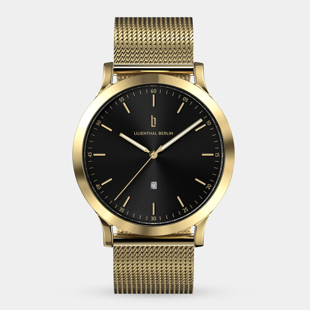 Gold mesh band watch with black dial, minimalist markers, and date display