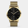 Gold mesh band watch with black dial, minimalist markers, and date display