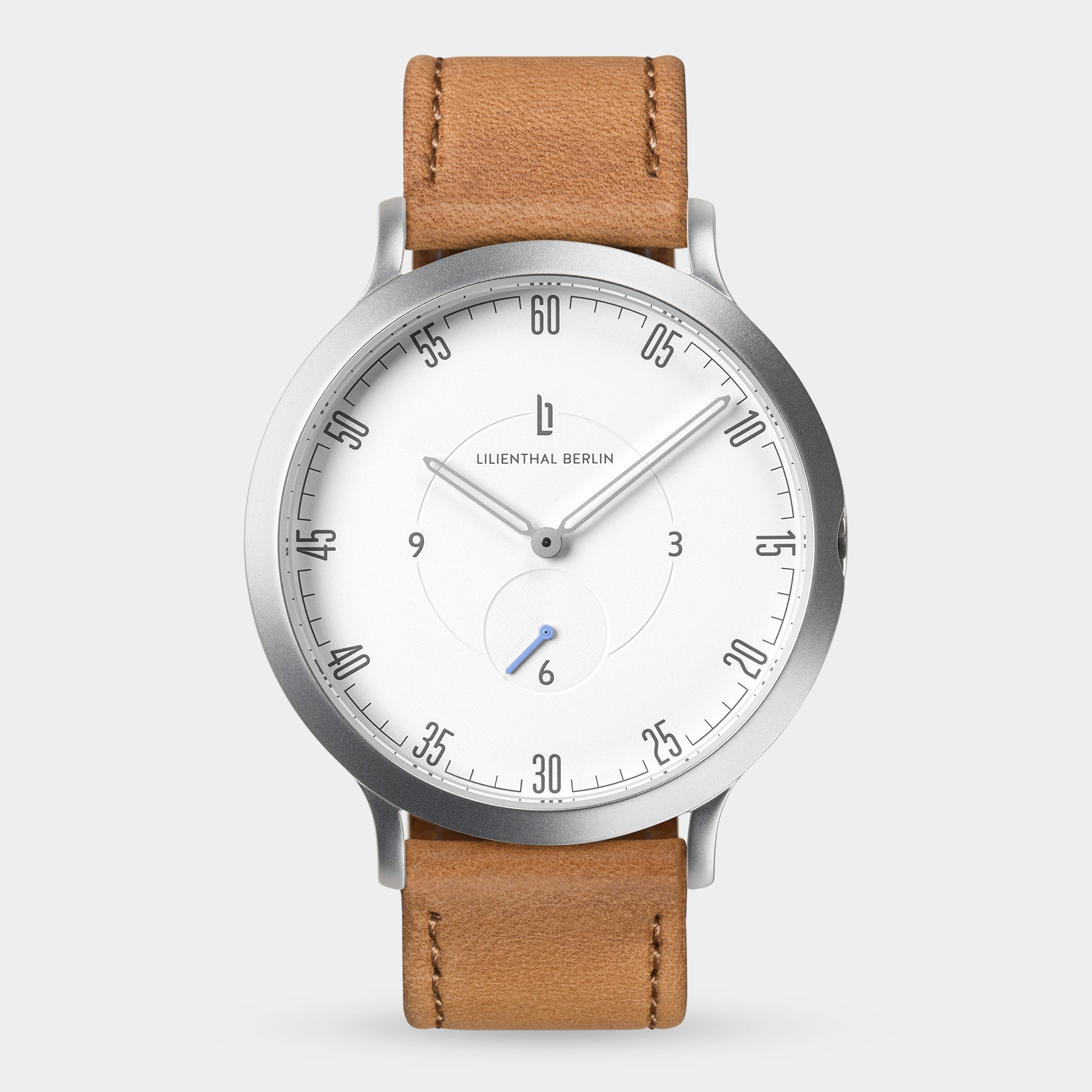 Minimalist watch with white dial, tan leather strap, and silver case on white background.