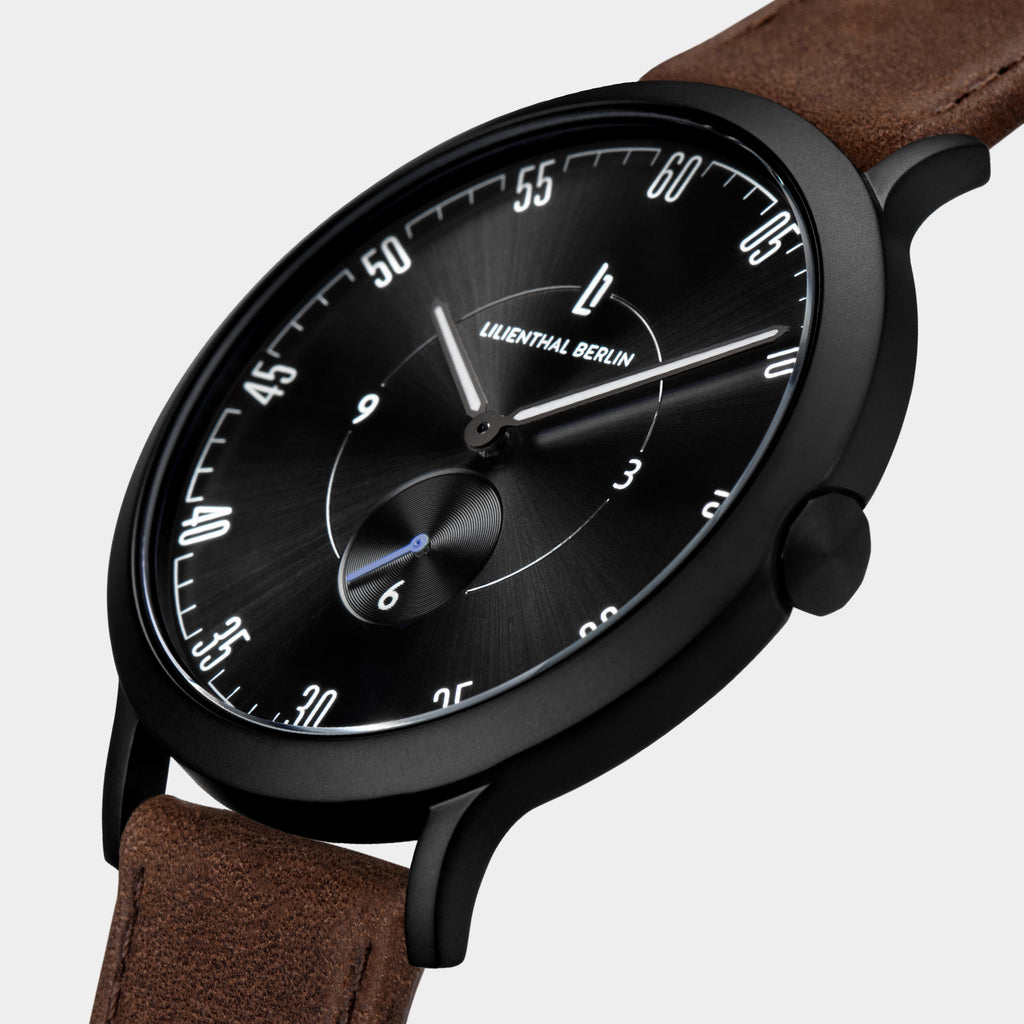 Black dial minimalist wristwatch with white indices and brown leather strap