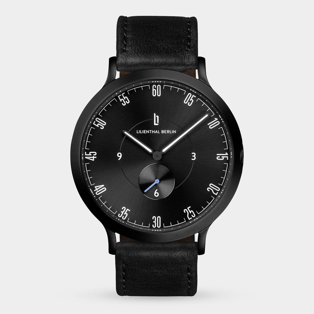 Black minimalist wristwatch with a black leather strap and sleek dial design