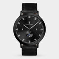 Black minimalist wristwatch with a black leather strap and sleek dial design