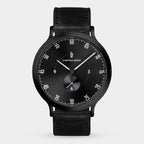 Black minimalist wristwatch with a black leather strap and sleek dial design