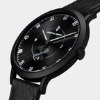 Minimalist black analog wristwatch with sunburst dial and black leather strap